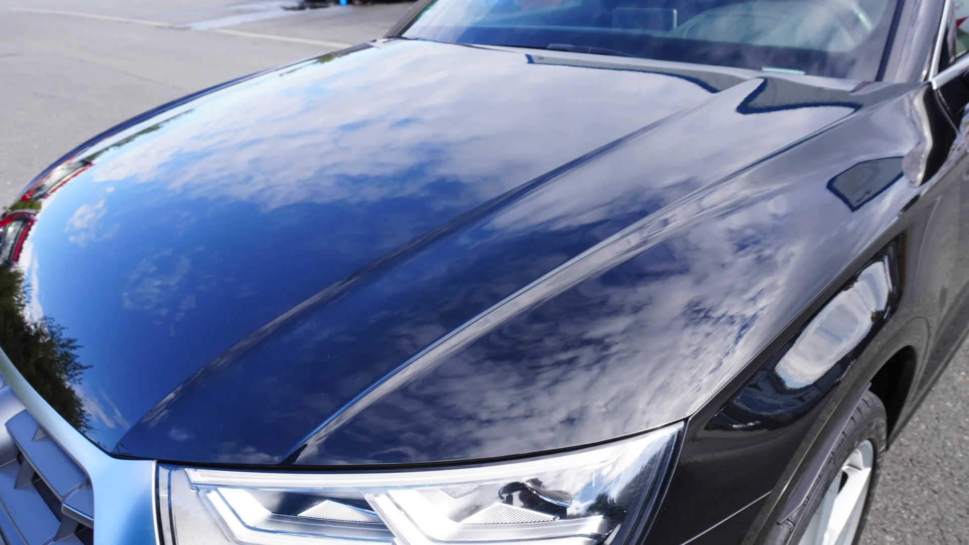 Spiegelungen auf der dunklen Motorhaube eines Audi